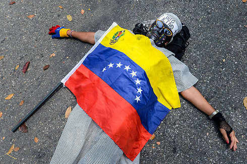 פעיל אופוזיציה בוונצואלה מוחה על מותו של תלמיד בן 14 במהלך הפגנה במדינת טאצ'ירה נגד המצב הכלכלי. הרשויות מסרו שיגישו כתב אישום נגד שוטר בגין מעורבות במות הנער (צילום: AFP) (צילום: AFP)
