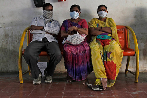 קרובי משפחה של חולים בשפעת העופות יושבים באגף הבידוד בבית החולים האזרחי באחמדבאד, הודו (צילום: AP) (צילום: AP)