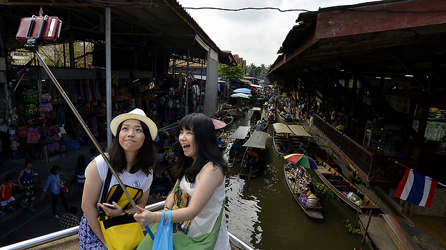 תיירות עם מקל סלפי בתאילנד, ארכיון. כדאי להיזהר (צילום: EPA) (צילום: EPA)