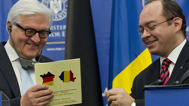 שר החוץ הגרמני לא שם לב לטעות. שטיינמאייר ועמיתו הרומני אורסקו עם השי שקיבל (צילום: AFP) (צילום: AFP)