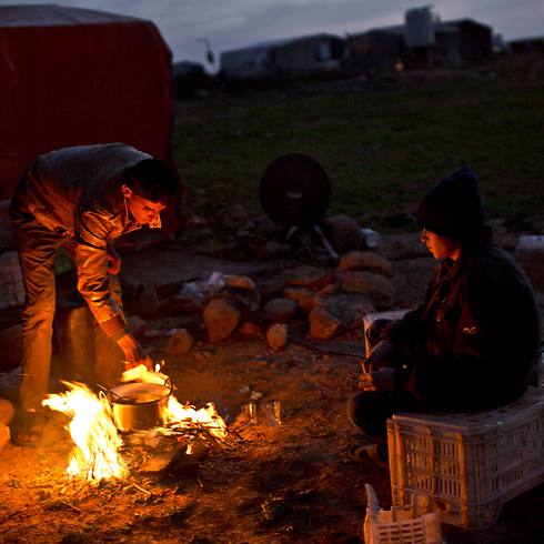 Teenager cook outside their tent in Jordan (Photo: AP)