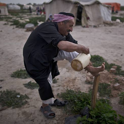 Syrian refugee washes his foot outside his tent in Jordan (Photo: AP)