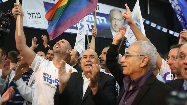 מצד שמאל בתמונה: עו"ד אמיר אוחנה מניף את דגל הגאווה בליכוד  (צילום: AFP) (צילום: AFP)