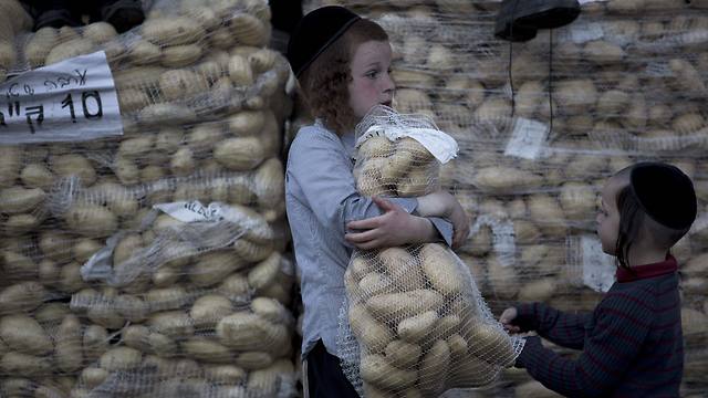An Ultra-Orthodox Jewish boy carries a bag of potatoes to be distributed to people in need during the preparations for Passover in the Mea Shearim neighborhood of Jerusalem (Photo: EPA)