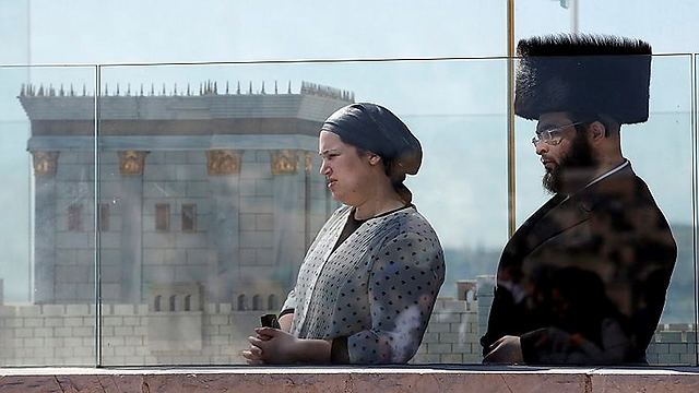 Watching beside a model of the Temple (Photo: AFP)
