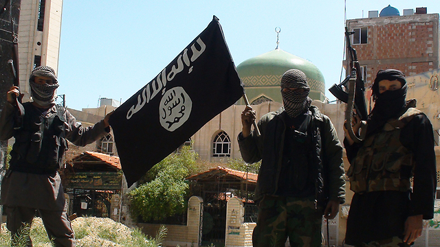 Islamic State militants waving the group's flag in Yarmouk
