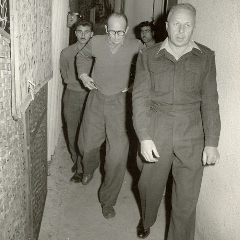 Eichmann being taken to a remand extension hearing.