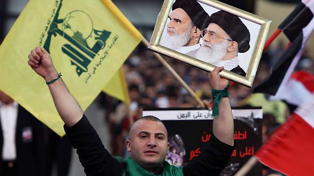 תומך בעצרת חיזבאללה בביירות עם תמונות המנהיגים הרוחניים של איראן (AP) (AP)