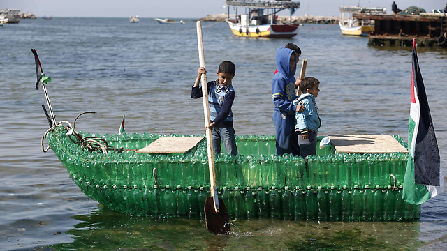 Palestinian children paddle in harbor (Photo: AFP)