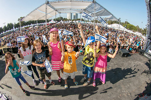 Children wave flags at an IAC event (Photo: AIC)
