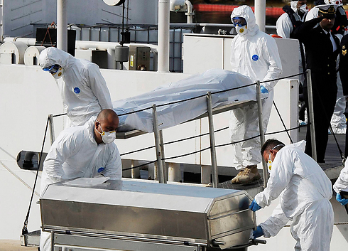 אנשי משמר החופים האיטלקי עם גופות של מהגרים שטבעו בצאתם מלוב (צילום: AP) (צילום: AP)