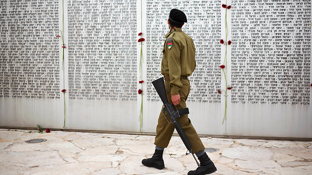 חייל עובר מול לוח הזיכרון בלטרון (צילום: AP) (צילום: AP)