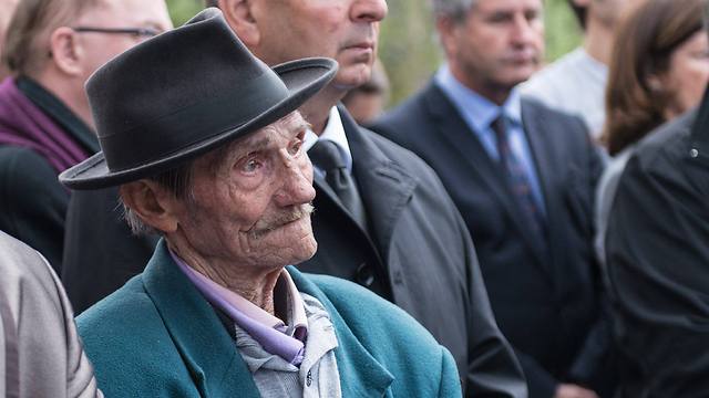 An unidentified Jewish survivor and other guests listen to Hollande during his visit (Photo: EPA)