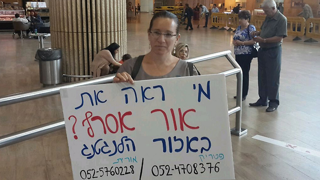Orit Asraf, mother of Or, at the airport with a sign asking if anyone had seen her son 