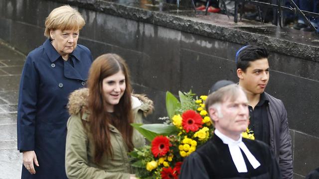 Merkel follows youths carrying flowers on memorial site for former Nazi concentration camp in Dachau (Photo: AP) (Photo: AP)