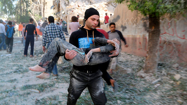 חילוץ ילד שנפצע בהפגזה של המשטר הסורי בחלב (צילום: רויטרס) (צילום: רויטרס)