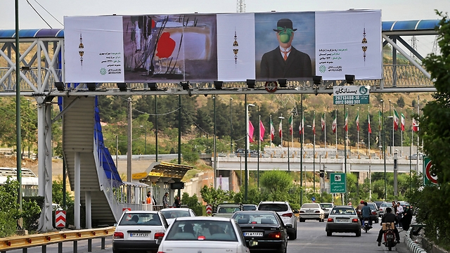 Belgian painter Rene Magritte's 'The Son of Man,' right, and a painting by late Iranian painter Sohrab Sepehri, over a highway in Tehran (Photo: Associated Press)