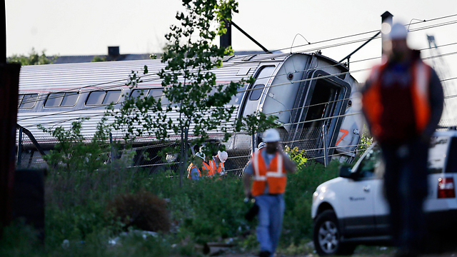 עובדי חילוץ והצלה ליד הריסות רכבת הנוסעים שירדה מהפסים והתהפכה בפילדלפיה. באסון נהרגו שמונה בני אדם ונפצעו יותר מ-200 (צילום:AP   ) (צילום:AP   )