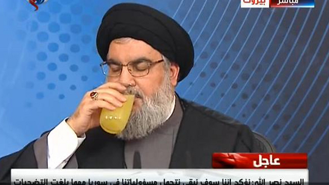 Nasrallah appears in good health as he pauses for a drink during a previous TV appearance.