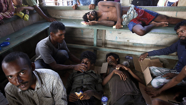 חלוקת אוכל ושתייה למהגרים בלתי חוקיים שהגיעו למחוז אצ'ה באינדונזיה. אינדונזיה ומלזיה הציעו להעניק מקלט זמני לאלפי פליטים רוהינגים שבמשך כמה שבועות היו לכודים בלב ים (צילום: AP) (צילום: AP)