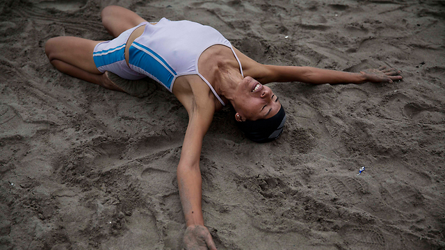 חואנה קוריפונה עושה מתיחות ויוגה על החול (צילום: AP) (צילום: AP)