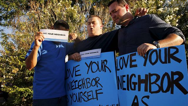Counter protesters calling to 'Love your neighbor' (Photo: Reuters)