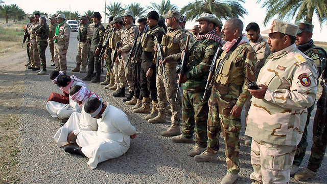 Shia militias in Iraq watch over captured ISIS fighters. (Photo: AP) (Photo: AP)