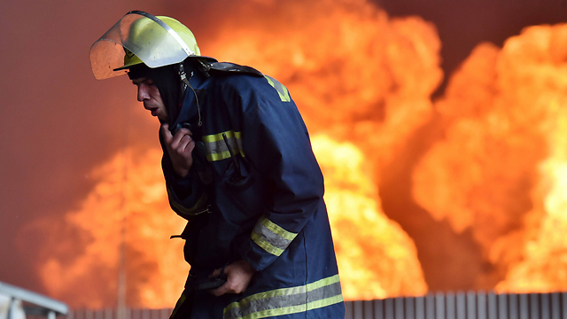 המצב בשליטה? כבאי מתקשה לנשום ליד השריפה הגדולה (צילום: AFP) (צילום: AFP)