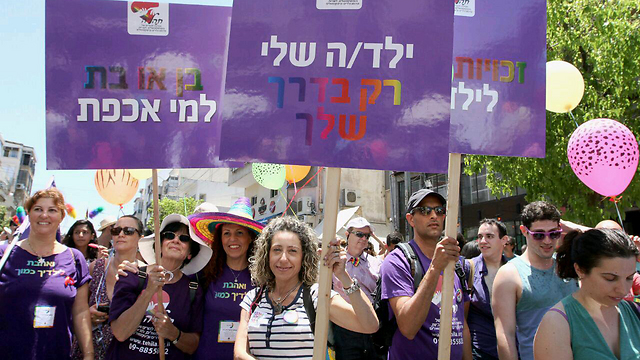 Marchers walk with signs saying: 'My child, only your way' and 'boy or girl, who cares' (Photo: Ido Erez)