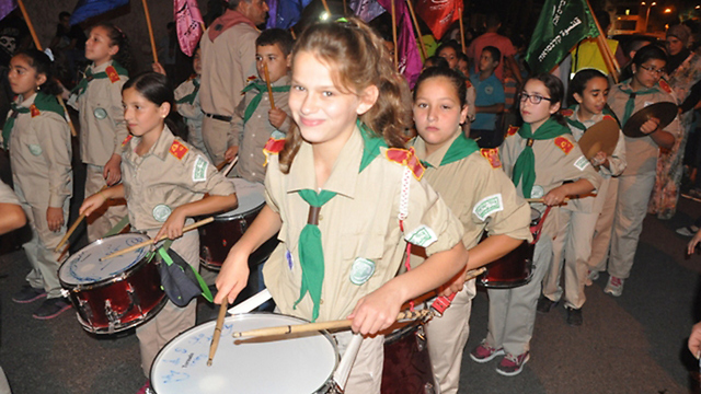 Youngsters play drums in the procession in Qalansawe