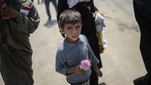 ילד סורי שברח ממלחמת האזרחים בארצו מגיע לגבול עם טורקיה ובידו ורד. מאז פרוץ המשבר בסוריה במרס 2011 קלטה טורקיה 1.8 מיליון פליטים סורים (צילום: AFP) (צילום: AFP)