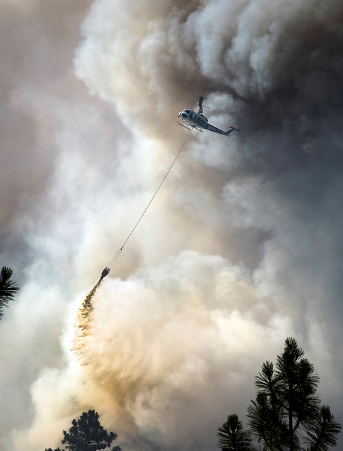 מסוק מתיז מים לעבר שריפה שפרצה באזור העיר ספוקיין במדינת וושינגטון (צילום: AP) (צילום: AP)