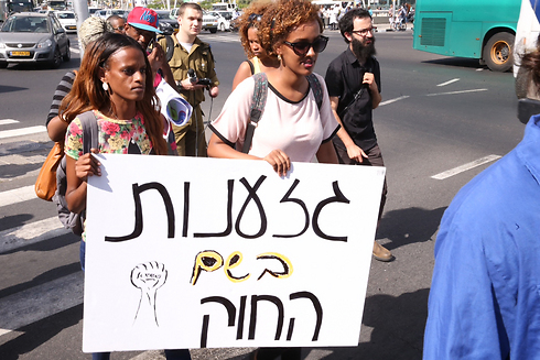 Protesters hold sign saying 'Racism in the name of the law' (Photo: Motti Kimchi)