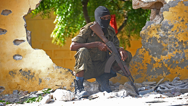 חייל סומלי בזירת פיגוע שביצע ארגון הטרור האיסלאמיסטי "א-שבאב" במטה המודיעין הצבאי במוגדישו (צילום: AFP) (צילום: AFP)