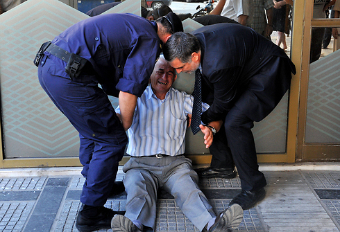 פנסיונר מבכה את מר גורלו בסלוניקי (צילום: AFP) (צילום: AFP)