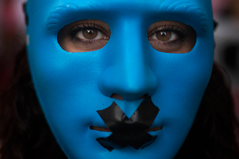 מפגין עוטה מסיכה כחולה על פניו בהפגנה שנערכה במדריד נגד החוק החדש שמגביל את חופש הביטוי והתקשורת (צילום: AP) (צילום: AP)