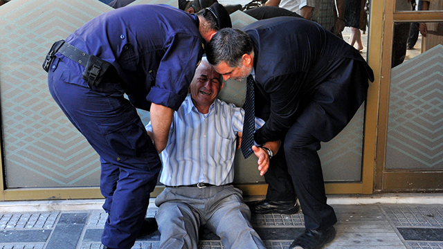 התמונה שריגשה את העולם: פנסיונר יווני עובר מבנק לבנק, לא מצליח למשוך כסף - ומתמוטט (צילום: AFP) (צילום: AFP)