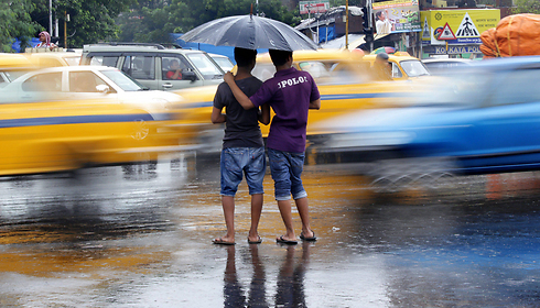 גשמי המונסון העונתיים פוקדים את העיר כלכותה שבהודו, שוטפים את הרחובות ומשבשים את חיי היומיום (צילום: EPA) (צילום: EPA)