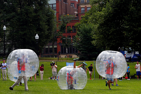 בבוסטון קומון, הפארק הציבורי המרכזי בעיר בוסטון, ניצלו את זמן ארוחת הצהריים למשחק כדורגל בועות. כחלק מהמשחק לובשים השחקנים בועות פלסטיק שקופות מלאות באוויר (צילום: רויטרס) (צילום: רויטרס)