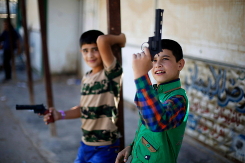 ילדים סורים שברחו עם משפחותיהם לירדן עקב מלחמת האזרחים משחקים באקדחי צעצוע במהלך היום הראשון של עיד אל-פיטר לציון סוף חודש הרמדאן (צילום: רויטרס) (צילום: רויטרס)