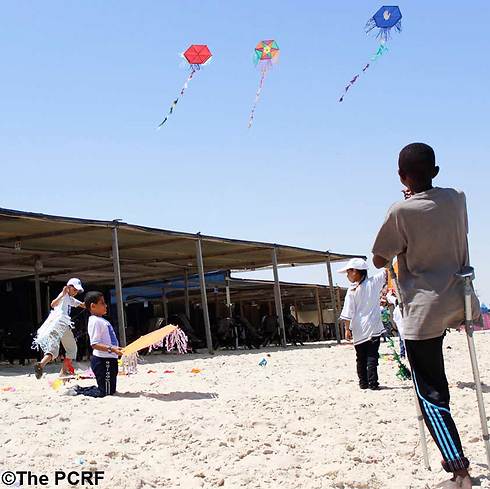 In a picture taken by one of the young Gazans, children play with kites on the beach (Photo: Ibtesam Abu Thaher/PCRF)
