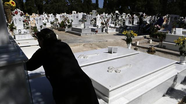 קשישה בבית קברות במזרח אתונה (צילום: AP) (צילום: AP)