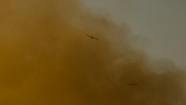 Aircraft dive in and out of the smoke. (Photo: Eli Bazri) (Photo: Eli Bazri)