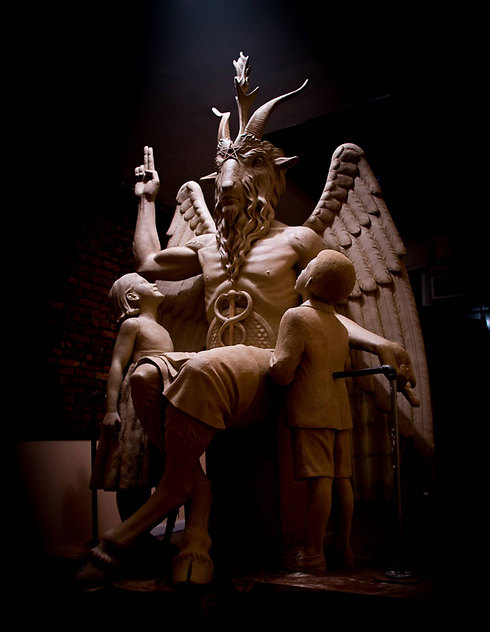 פסלים של ילד וילדה מביטים בהערצה לפסל של השטן שהוצב בדטרויט (צילום: AP) (צילום: AP)