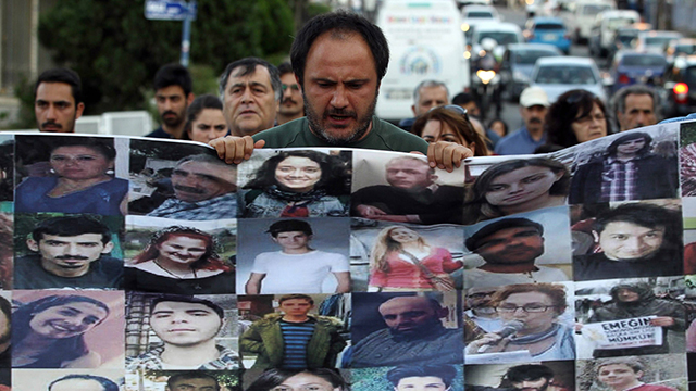 מפגין באיסטנבול עם תמונות ההרוגים בפיגוע בסורוץ' (צילום: AFP) (צילום: AFP)