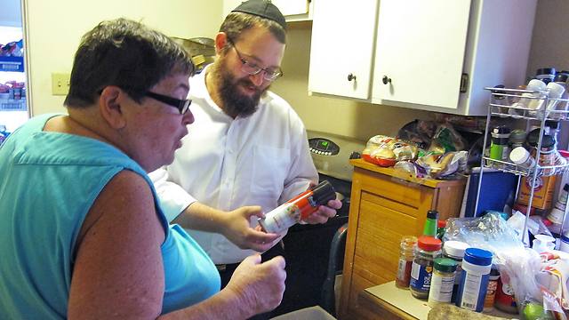 Dovid Lepkivker points out a kosher certification label on a container as Beth Pagel gives him a tour of her kitchen, in Helena, Mont. (Photo: AP)