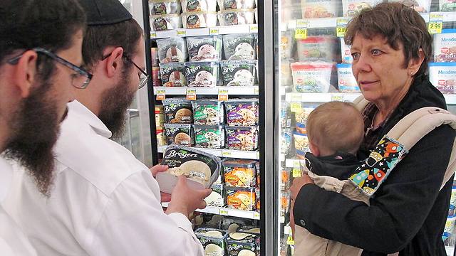 Dovid Lepkivker and Eli Chaikin inspect ice cream with Mary Semple and her grandson Levi Weitner in a grocery store in Helena, Mont. (Photo: AP)