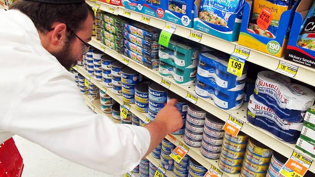 Dovid Lepkivker looks through cans of tuna in a grocery store in Helena, Mont. (Photo: AP)