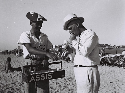 מוכר מיץ "עסיס" ולקוח בחוף ימה של תל אביב, 1934 (צילום: זולטן קלוגר) (צילום: זולטן קלוגר)