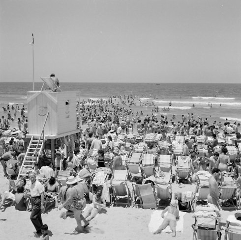 ההמונים מבלים בחוף הים, שימו לב לתחנת ההצלה ולמציל שיושב על הגג, 1964 (צילום: Williem Ven De Poll) (צילום: Williem Ven De Poll)
